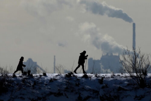 People cross-country ski in the cold weather as an industrial plant is shown in the back ground in Toronto on Friday, Feb. 4, 2022. Nathan Denette/The Canadian Press. 