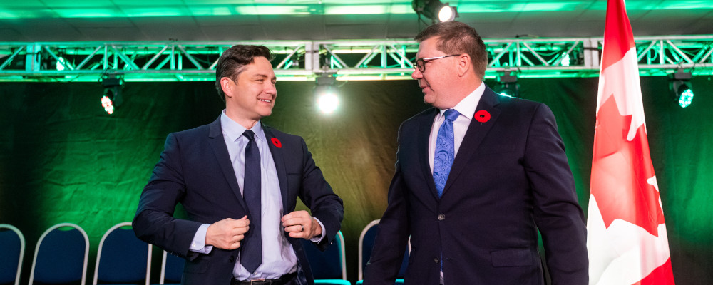 Conservative Party Leader Pierre Poilievre, left, and Saskatchewan Premier Scott Moe, right, stand on stage during Saskatchewan Party Convention in Regina on Saturday, November 4, 2023. Heywood Yu/The Canadian Press. 