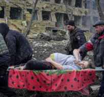 Ukrainian emergency workers and volunteers carry an injured pregnant woman from a maternity hospital damaged by an airstrike in Mariupol, Ukraine, on March 9, 2022. Evgeniy Maloletka/AP Photo.