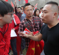 Pro-China counter-protesters, wearing red, shout down a man in a black shirt during an anti-extradition rally for Hong Kong in Vancouver on Saturday August 17, 2019. Darryl Dyck/The Canadian Press. 
