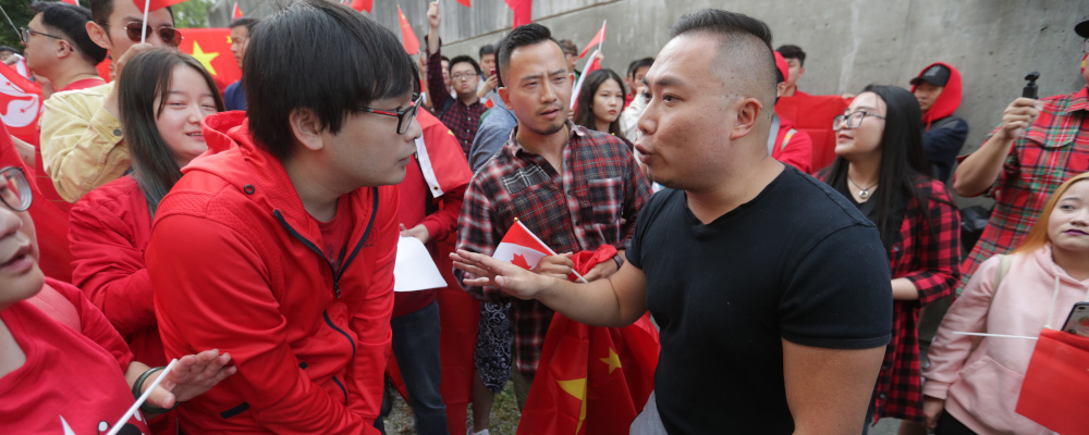Pro-China counter-protesters, wearing red, shout down a man in a black shirt during an anti-extradition rally for Hong Kong in Vancouver on Saturday August 17, 2019. Darryl Dyck/The Canadian Press. 