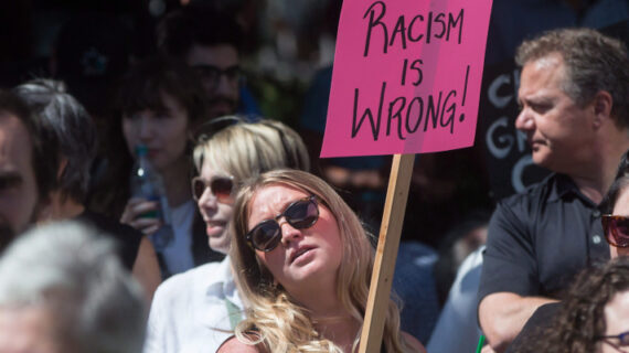 A woman holds a sign during an anti-racism rally held as a counter protest to an alt-right rally at City Hall in Vancouver, B.C., on Saturday August 19, 2017. Darryl Dyck/The Canadian Press. 