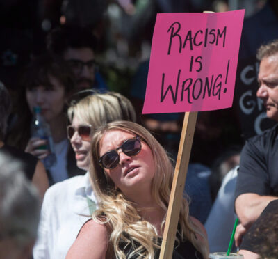 A woman holds a sign during an anti-racism rally held as a counter protest to an alt-right rally at City Hall in Vancouver, B.C., on Saturday August 19, 2017. THE CANADIAN PRESS/Darryl Dyck