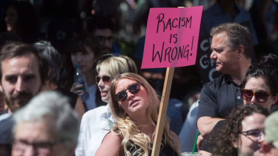 A woman holds a sign during an anti-racism rally held as a counter protest to an alt-right rally at City Hall in Vancouver, B.C., on Saturday August 19, 2017. THE CANADIAN PRESS/Darryl Dyck