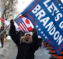 A person waves a "Let’s Go Brandon" flag, code for an expletive against U.S. President Joe Biden used by supporters of former U.S. President Donald Trump, during a rally against COVID-19 restrictions in Ottawa, on Saturday, Jan. 29, 2022. Justin Tang/The Canadian Press. 