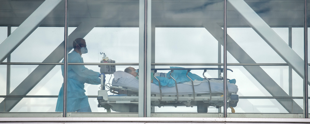 A health-care worker pushes a patient across a connecting bridge at a hospital in Montreal, Thursday, July 14, 2022. Graham Hughes/The Canadian Press. 