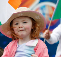 A girl waves the Irish flag as people gather to watch the parade, in Belfast, Northern Ireland, Sunday April 9, 2023. Peter Morrison/AP Photo. 