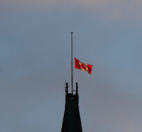 The sun catches the Canadian flag as it flies at half mast on the Peace Tower, Tuesday, March 19, 2024 in Ottawa. Adrian Wyld/The Canadian Press. 