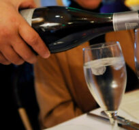 A waiter pours a bottle of red wine at a restaurant in Los Angeles, Wednesday, April 8, 2009. Chris Pizzello/AP Photo. 