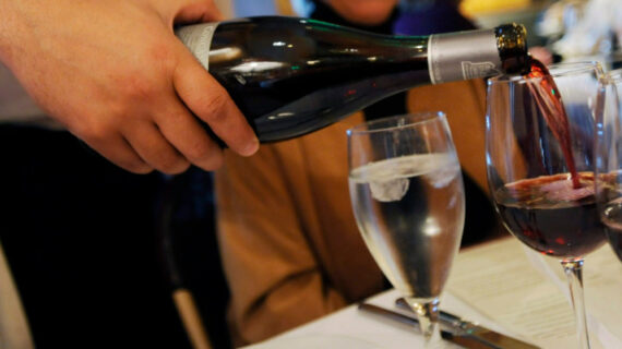 A waiter pours a bottle of red wine at a restaurant in Los Angeles, Wednesday, April 8, 2009. Chris Pizzello/AP Photo. 