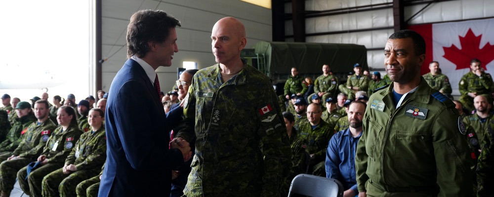 Prime Minister Justin Trudeau shakes hands with Chief of Defence Staff Gen. Wayne Eyre following a press conference regarding Canada's new defence policy in Trenton, Ont., Monday, April 8, 2024. Sean Kilpatrick/The Canadian Press.